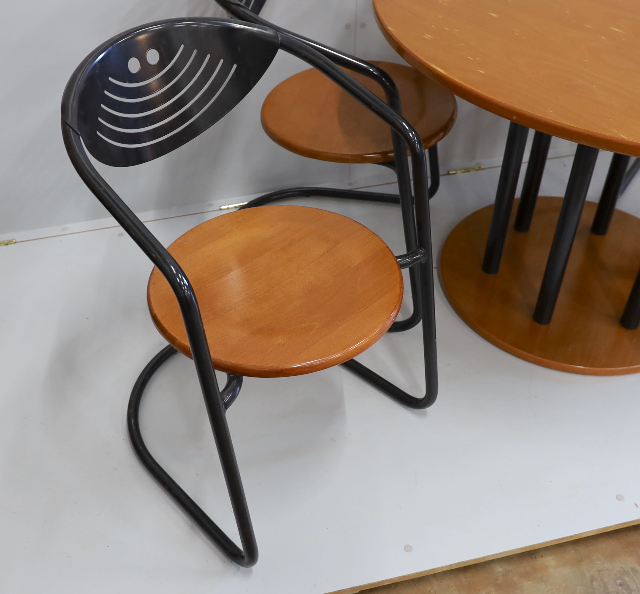 A mid century circular beech table and four cantilever chairs, table 110cm diameter, height 73cm.